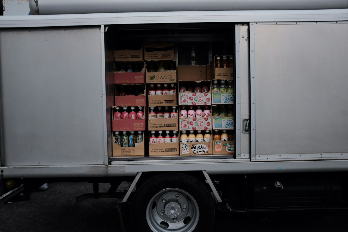 Camión de reparto con el lateral abierto y cajas de bebidas